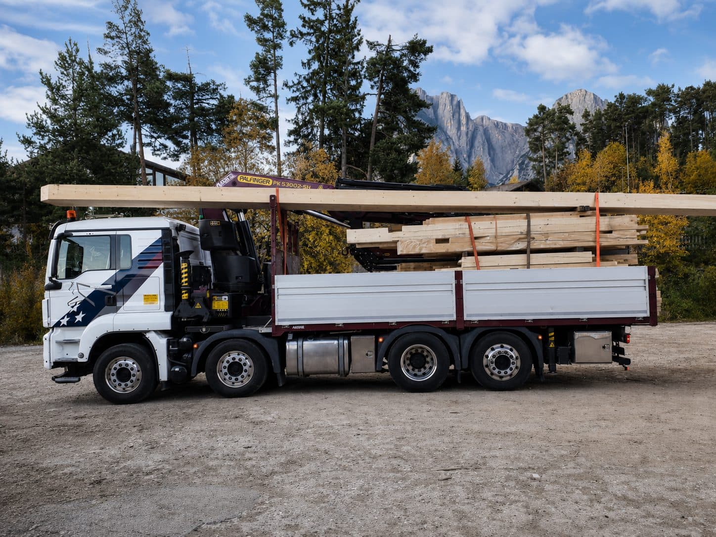 Holztransport mit Ladekran der Mair Josef GmbH vor den Dolomiten